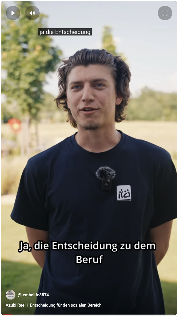 Junge Person in dunkelblauem T-Shirt mit Mikrofon spricht draußen vor der Kamera. Untertitel: „Ja, die Entscheidung zu dem Beruf“