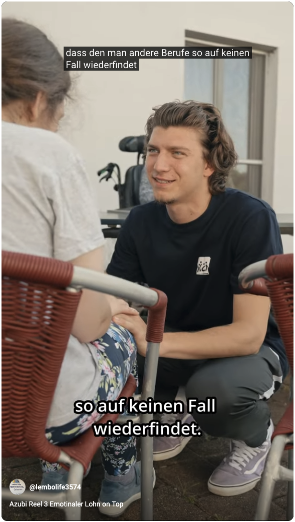 Junger Mitarbeiter hockt lächelnd vor einer Bewohnerin und hält ihre Hand. Untertitel: „so auf keinen Fall wiederfindet“