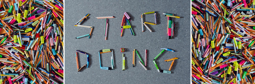 Bunte Stifte und Marker liegen dicht nebeneinander, in der Mitte formen sie auf grauem Untergrund den Schriftzug Start Doing, eingerahmt von chaotisch angeordnetem Zeichenmaterial